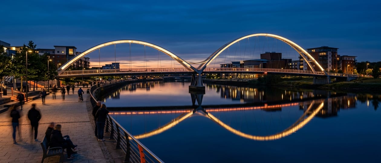 The Infinity Bridge in Stockton-on-Tees lit up at dusk, reflected in the River Tees